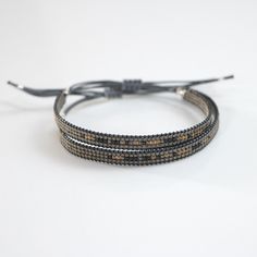 two bracelets with black and brown beads on a white background, one has a string attached to it