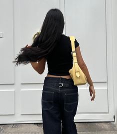 butter yellow outfit A simple stylish look: a fitted black top and wide-leg dark denim jeans, perfect for a relaxed day out. The butter yellow bag adds a pop of color, while white sneakers keep it comfortable and casual. Dark Denim Jeans, Yellow Outfit, Dark Denim, White Sneakers, Black Outfit