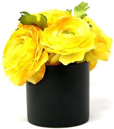 a black vase with yellow flowers in it