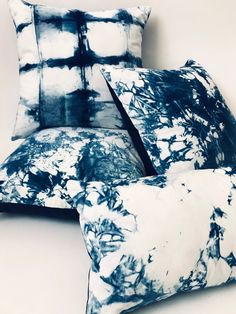 two blue and white pillows sitting next to each other