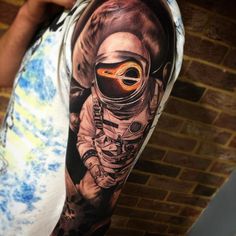 a man's arm with an astronaut tattoo on it