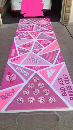 a pink table with stickers on it in front of a white van and door