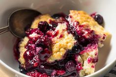 blueberry cobbler in a white bowl with a spoon