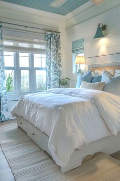 a large bed sitting in a bedroom next to a window with blue drapes on it