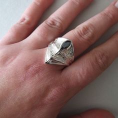 This is a perfect statement ring for men who love unique and impressive jewelry. It's inspired by medieval armor and has designs engraved on the front side. It is made of sterling silver. There is an option to set a black Onyx stone or a dark blue, red, or green cubic zirconia stone. Its maximum width on the front is 1 inch ( 2.6 cm ) and it is hollow inside. Please write the ring size you want when you order. If you're uncertain of your ring size, you can first order this reusable plastic ring Modern Diamond Cut Signet Ring As Gift, Modern Diamond Cut Signet Ring Gift, Modern Diamond Cut Rings For Gift, Unique Gemstone Signet Ring As Gift, Knight Ring, Silver Armor, Ring Armor, Armor Ring, Mens Gemstone Rings