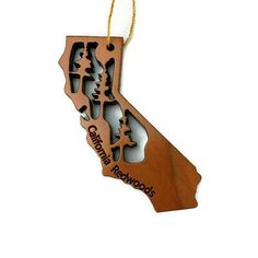 a wooden ornament shaped like the state of california with trees and mountains on it