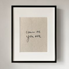 a handwritten message on a piece of paper in a black frame hanging on a wall