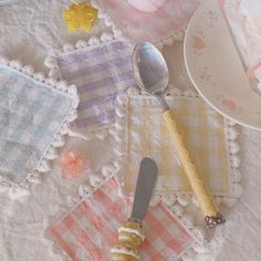 a table topped with plates and napkins next to a cake on top of a doily