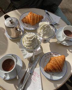 a table topped with pastries and cups of coffee