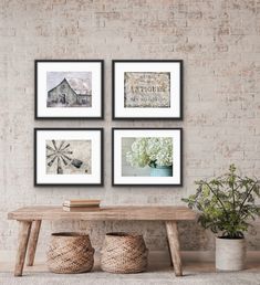 four framed pictures hanging on a brick wall above a wooden table with two vases