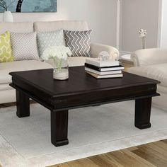 a living room with white couches and a coffee table in front of the couch