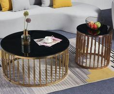 two tables with drinks on them in front of a white couch and yellow throw pillows