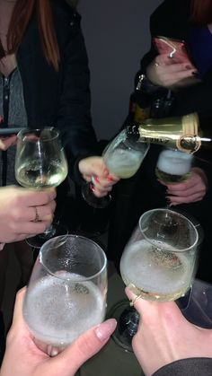 several people are holding wine glasses and toasting