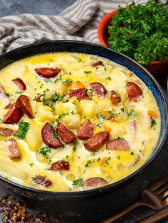 there is a bowl of soup with ham and cheese in it next to some parsley