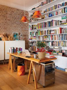 an image of a home office with lots of books on the shelves and desks