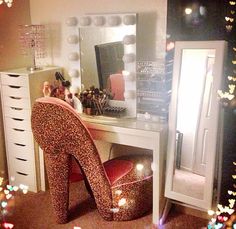 a leopard print high heeled shoe sits in front of a vanity with a lighted mirror