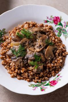 a white plate topped with mushrooms and lentils on top of a table next to a red flowered napkin