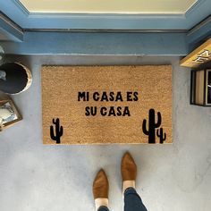 a person standing in front of a door mat with the words mcasa es sucasa on it