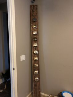 a tall wooden pole with metal bowls on it's sides in front of a door