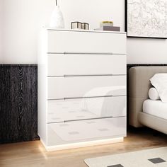 a white dresser sitting next to a bed in a bedroom