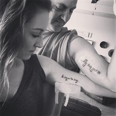 a man and woman are looking at each other with tattoos on their arms that say, my love is in the air