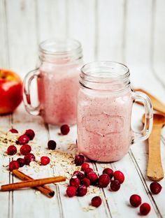 two mason jars filled with oatmeal and cranberries next to cinnamon sticks