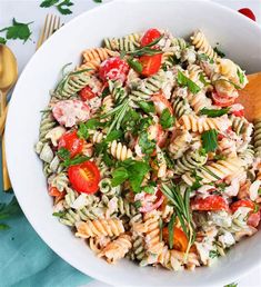 a white bowl filled with pasta salad on top of a table