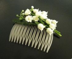 a white comb with flowers on it sitting on a table