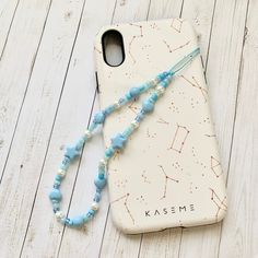 a cell phone case with a blue beaded necklace attached to the back of it