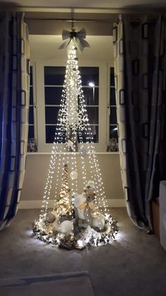 a decorated christmas tree in front of a window