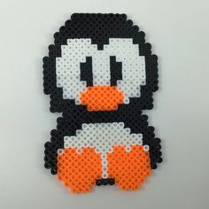 an orange and black penguin made out of perler beads