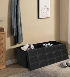 a living room with a black storage box on the floor next to a pair of slippers