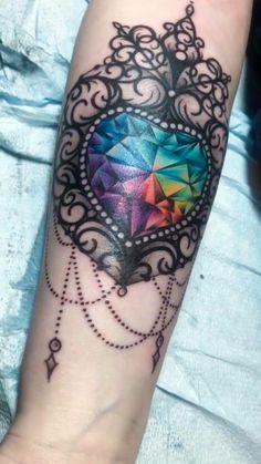 a colorful diamond tattoo on the arm