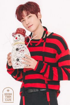 a young man is holding a snowman ornament