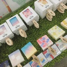 many different types of soaps are on display in the grass with tags attached to them