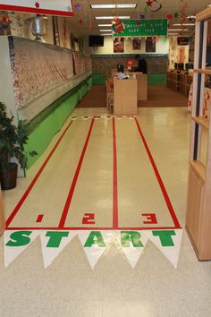 the inside of a store with red and green stripes on the floor that says start