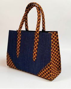 African print handbag Statement handbag with Jean Hand-crafted using African print fabric Size: 14 by 10 by 4.5 African Fabric Accessories, Ankara Bags, Modern Handbag, Handmade Fabric Bags, African Bag, Statement Handbag, Hand Bags For Women, African Accessories, Diy Bag Designs