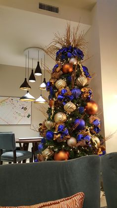 a decorated christmas tree with blue and gold ornaments