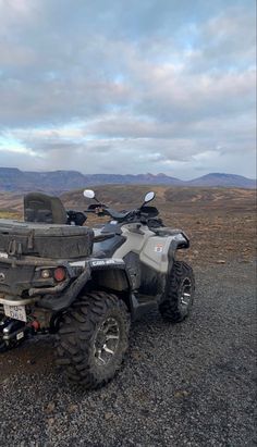 an atv parked on the side of a dirt road