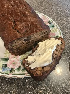 there is a loaf of bread on the plate with whipped cream in between it and another piece of cake