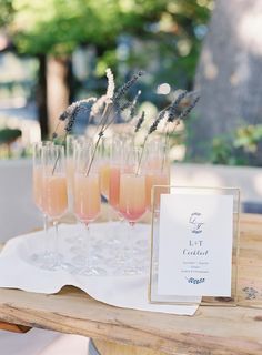 there are many glasses with drinks on the table next to each other and a sign