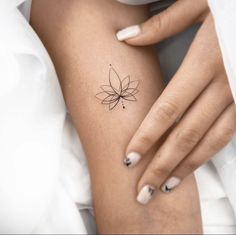 a woman's arm with a small flower tattoo on the left side of her body