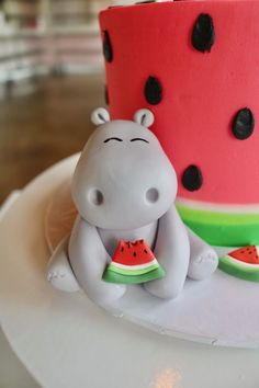 a cake that looks like a hippo with watermelon slices on the side