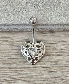 This ornate silver heart features crystals in a gorgeous elegant design, that's minimalistic enough for everyday wear. Drop jaws with this body jewelry. Also available in gold! Details & Size: ♥ 316L Surgical Steel ♥ 10mm bar, 14G ♥ Every purchase comes with an Elara gift box Please message me if you have any questions We hope you love our jewelry as much as we do! Silver Heart Belly Rings For Valentine's Day, Elegant Heart-shaped Belly Rings, Valentine's Day Silver Heart Belly Rings, Valentine's Day Gift Silver Belly Rings, Elegant Heart-shaped Wedding Belly Rings, Elegant Heart-shaped Internally Threaded Belly Rings, Silver Belly Rings For Valentine's Day, Nickel Free Elegant Heart Ring, Elegant Nickel-free Heart Ring