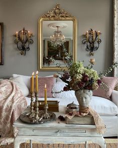 a living room filled with lots of furniture and flowers on top of a coffee table