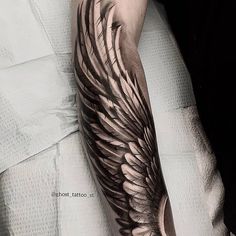 a man with a wing tattoo on his arm