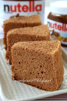 three pieces of bread sitting on top of a white plate next to nutella butter