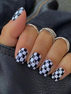 a woman's hand with black and white checkered nails