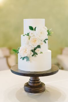 a white wedding cake with flowers on top