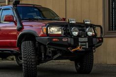 a red pick up truck parked in front of a building